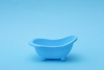 Miniature plastic bath on a blue background