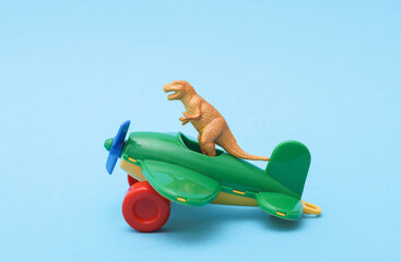 Dinosaur in toy airplane on a blue background
