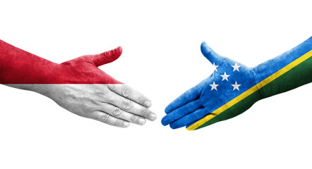 Handshake between Solomon Islands and Monaco flags painted on hands, isolated transparent image.