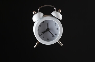 White alarm clock isolated on black background