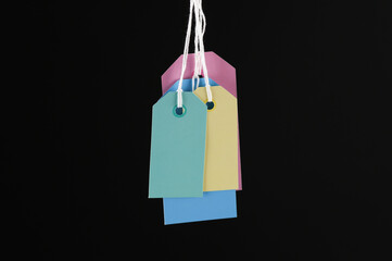 Lots of price tags hanging on ropes, isolated black background