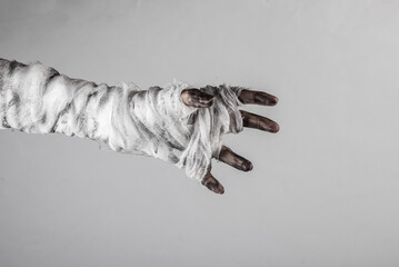 Mummy's hand wrapped in a bandage isolated on a black background. Halloween concept