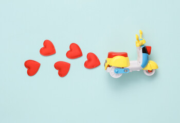 Toy moped with hearts on bue background. Romantic, love concept