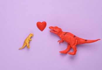 Two Toy tyrannosaurus rex with heart on a purple background. Romantic, love, valentine's day concept