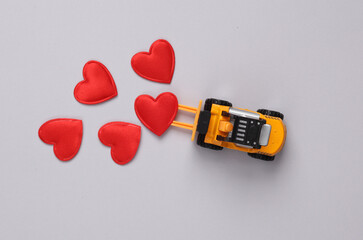 Toy forklift with hearts on gray background. Love, romance, valentine's day, February 14 concept