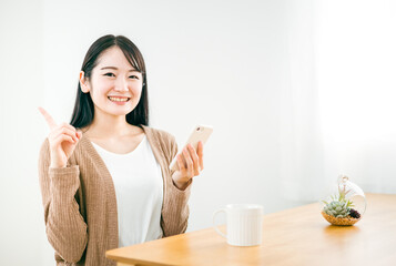 家でスマホを使う日本人女性
