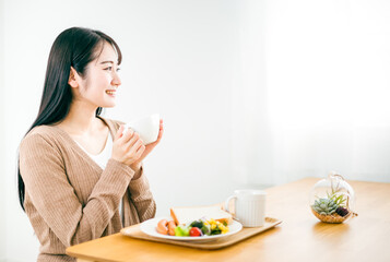 朝食にスープを飲む日本人女性（ご飯）

