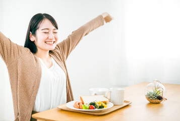 Obraz na płótnie Canvas 起床して朝食を食べる日本人女性 