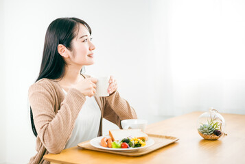 朝食でスープを飲む日本人女性（ご飯）
