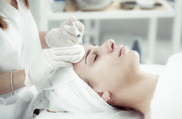 Obraz na płótnie Canvas Face Injection. Anti Aging Biorevitalization In Cosmetic Salon.Young beauty Girl Is Receiving Hyaluronic Acid Skincare. Beautician Hands With Filler In Syringe