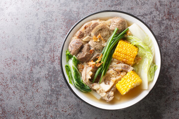 Bulalo is a Filipino stew made from beef shanks and marrow bones closeup in the bowl on the table. Horizontal top view from above