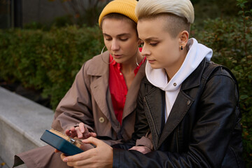 Brunette teaches a blonde to play a portable finger piano