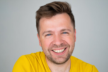 Obraz premium Handsome young man smiling while standing isolated on white background