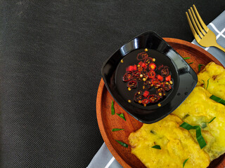 Mendoan, Indonesian traditional food. Tempe covered in flour, fried and served with spicy soy sauce. Flat lay with copy scape