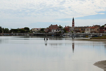 Fototapeta na wymiar Venetion lagoon and bell tower of church in CAVALLINO Town in Italy