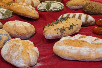 many loaves of bread made with mixed flour and seeds freshly baked by the baker