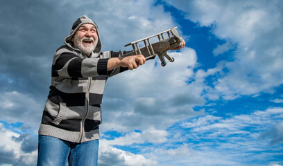 senior man on sky background, copy space. senior man at retirement. senior man with toy plane