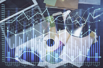 Financial market graph and top view computer on the desktop background. Multi exposure. Investment concept.