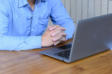 Executives holding hands looking at laptop screens