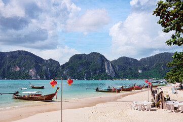 Beautiful landscape with traditional longtail boats, rocks, cliffs, tropical white sand beach. Traveling by Thailand.