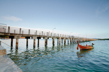 Fototapeta premium Traveling by Thailand. Landscape with sea lagoon, pier and traditional fishing longtail boat.
