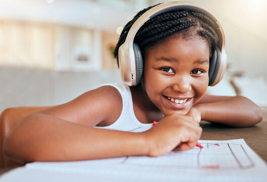 Online education, headphones and african girl in portrait writing, drawing and learning at home in virtual class happy with her language audio assessment. Black student child in elearning video call