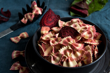 schüssel mit rotweiß gestreifer farfalle und rote Bete chips