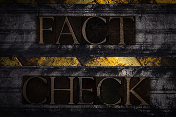 Fact Check text with on grunge textured copper and gold background 