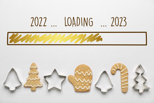 Christmas greeting card with cookies and cutters on light background