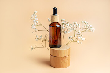 Bamboo cream jar and dropper bottle with face oil on a beige background. Cosmetic container...