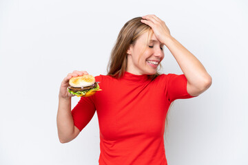 Young blonde woman holding a burger isolated on white background has realized something and intending the solution