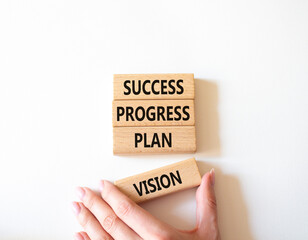 Success Progress Plan Vision symbol. Concept words Success Progress Plan Vision on wooden blocks. Beautiful white background. Businessman hand. Business concept. Copy space.