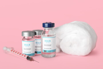 Bottles of insulin, syringe and cotton wool on color background