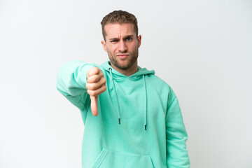 Young handsome caucasian man isolated on white background showing thumb down with negative expression