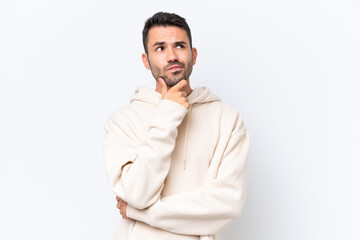 Young caucasian man isolated on white background having doubts