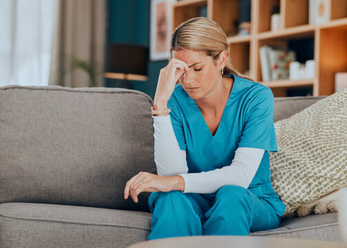 Worry, stress and burnout woman nurse sitting on sofa of modern apartment home sad with depression from work. Hand on head, anxiety and tired nursing in mental health distress on couch of living room