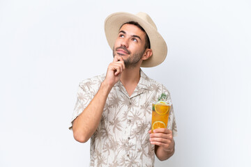 Fototapeta premium Young caucasian man holding a cocktail isolated on white background and looking up