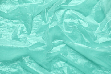 Crumpled polyethylene on mint background, closeup