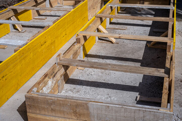 Works in the street. Trench with yellow timbers and metal bars to create the foundation of a house structure. Tenerife, Canary Islands, Spain 
