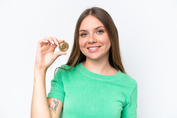 Young beautiful blonde woman holding a Bitcoin isolated on white background smiling a lot