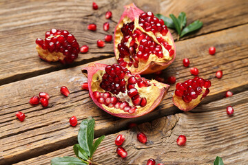 Fototapeta na wymiar Fresh ripe pomegranates on wooden background