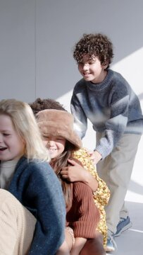 a young group of children playing together with a skateboard in a studio having fun