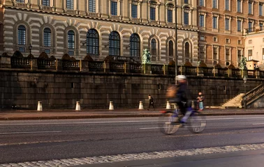 Deurstickers Commuter cyclists biking in bike lane in front of Stockholm Royal Palace an autumn morning with motion blur © Nicholas