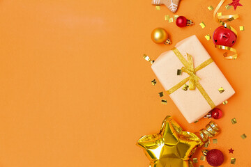 Composition with Christmas gift, decorations and confetti on color background