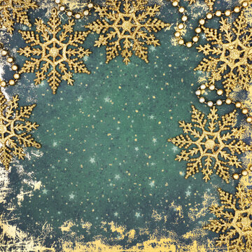 Christmas gold glitter snowflake background on grunge green. Sparkling tree decorations border for the festive holiday season.