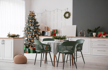 Interior of kitchen with Christmas tree, counters and dining table