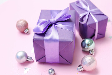 Christmas gifts and balls on pink background, closeup