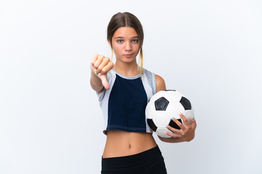 Little caucasian girl playing football isolated on white background showing thumb down with negative expression