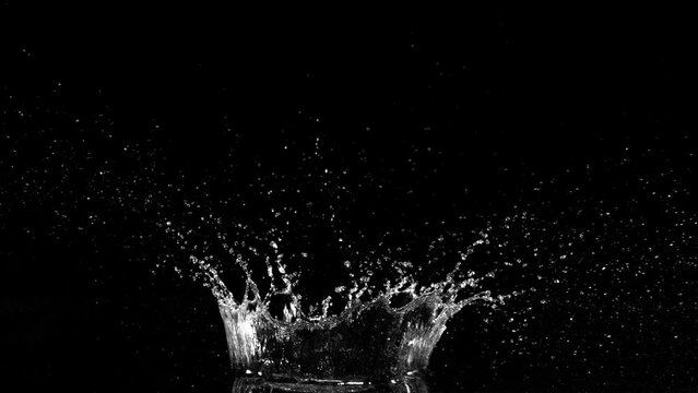 Super slow motion of splashing water crown shape on black background. Filmed on high speed cinema camera, 1000fps.
