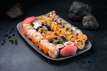 Assorted sushi roll set with salmon, tuna, shrimp, eel, avocado, cream cheese, cucumber on a plate.